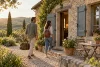 Un couple arrive avec ses bagages devant un gîte en pierre dans la campagne française.
